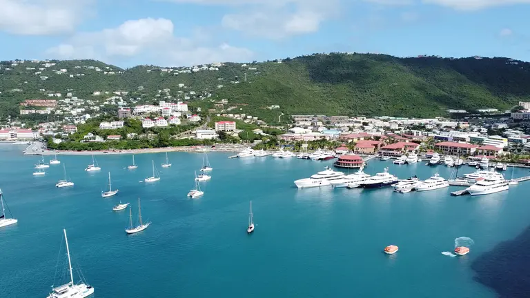 Aerial view of sailboats anchored off a harbor town