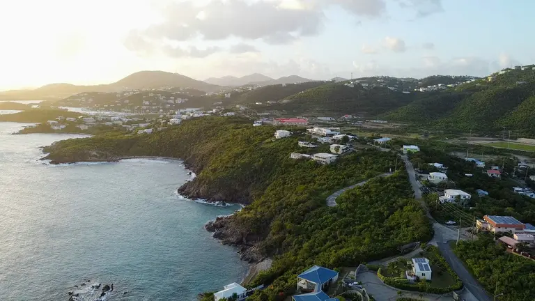 Aerial view of a hilly island coastline at sunset