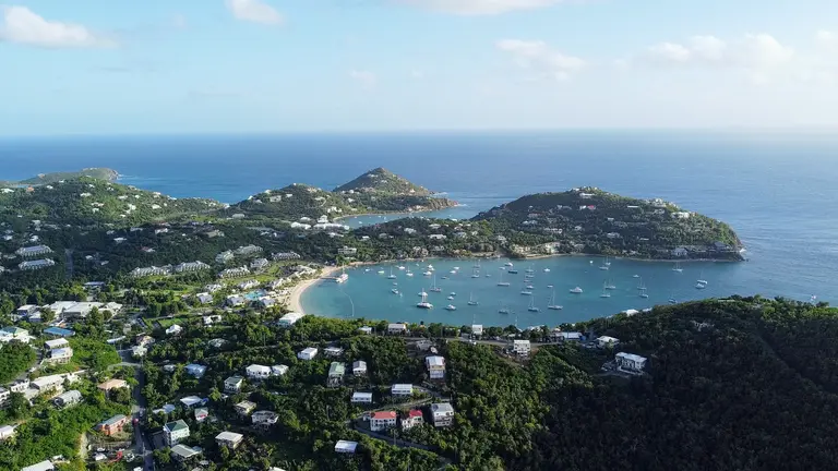 Aerial view of a sheltered bay below green hills